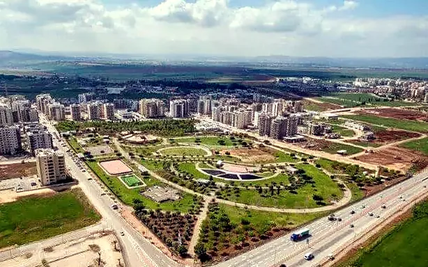 צילום אוויר מעמוד השיווק שבו נראים שכונה חדשה בעפולה, פארק, כביש והעמק. החלקה אינה מסומנת בצילום.