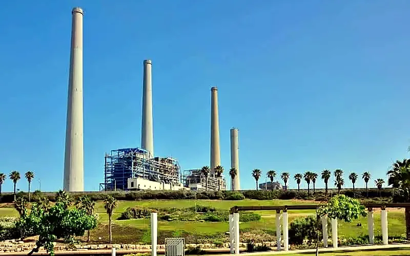 ארובות תחנת הכוח בחדרה מעבר לפארק של דשא ודקלים