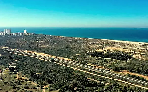 צילום רחפן של חולות וצמחייה במערב חדרה, וברקע כביש מהיר והים